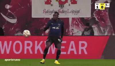 Soccer Player Kicking Ball In Front Of Workwear Sign GIF