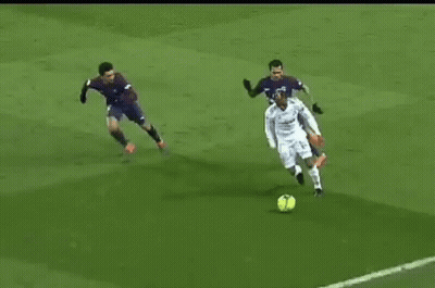 Soccer Player Kicking Ball While Defender Tries To Stop GIF
