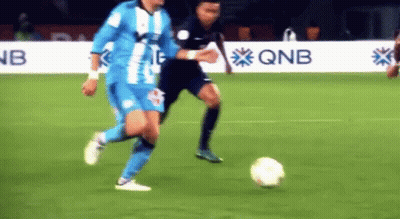 Soccer Player Kicking Ball With QNB In Background GIF