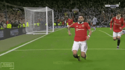 Soccer Player Kneeling While Another Runs Toward Him GIF
