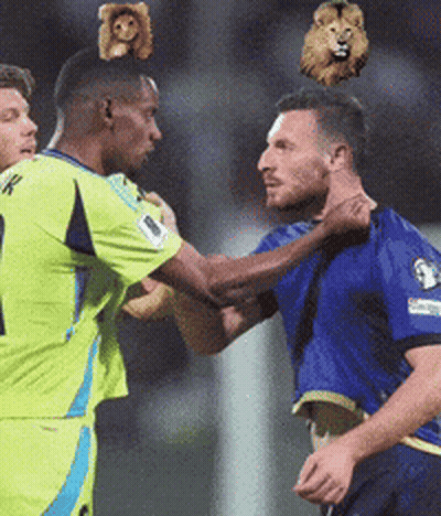 Soccer Player With Stuffed Animal On Head Being Tackled GIF