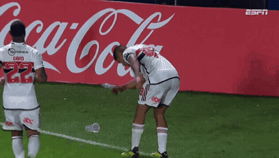 Soccer Players Celebrate A Goal In Front Of A Coca-Cola Advertisement GIF