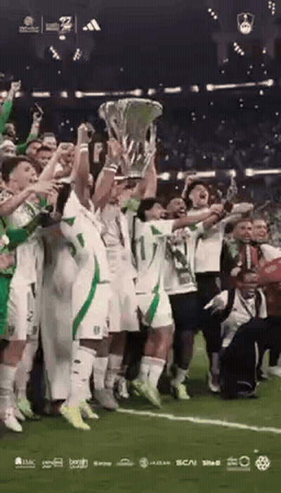Soccer Players Holding Trophy On Field GIF
