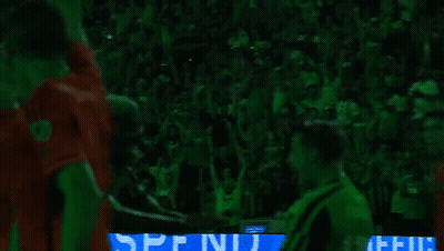 Soccer Players Hugging In Front Of Green Crowd GIF