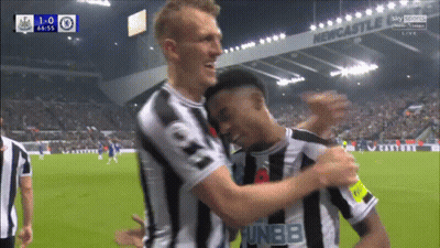 Soccer Players Hugging In Front Of Newcastle Sign GIF