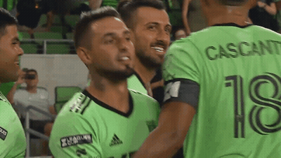 Soccer Players In Green Jersey Number 18 Hugging GIF