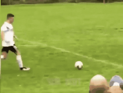 Soccer Players Playing, One Kneeling GIF