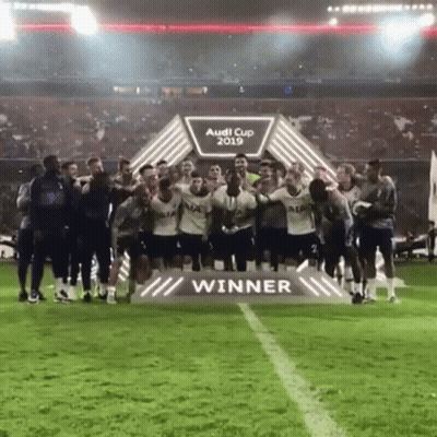 Soccer Players Posing In Front Of Audi Cup Winner Sign GIF