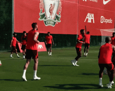 Soccer Players Practicing In Front Of Red Axa Expedia Sign GIF