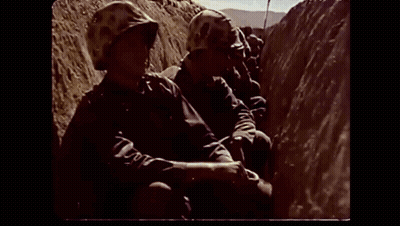 Soldier In Helmet Walking Down Dirt Hill GIF