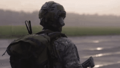 Soldier Walking On Wet Road With Backpack Gun GIF