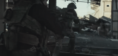 Soldier Walking Through Destroyed City With Gun GIF