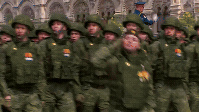 Soldiers In Green Uniforms Saluting In Front Of Old Building GIF