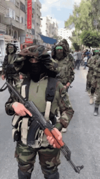 Soldiers Marching Down Street One Holding Gun GIF