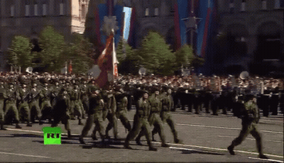 Soldiers Marching Down Street With Green RT Logo GIF