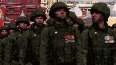 Soldiers Marching In Front Of Building With Victory Banner GIF