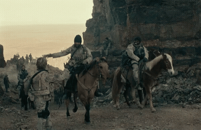 Soldiers Riding Horses On Dirt Road Near Ocean GIF