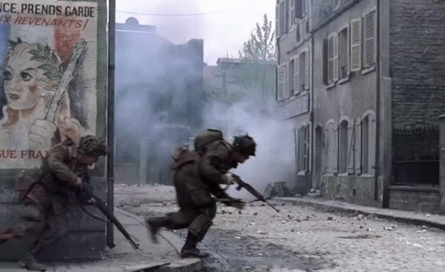 Soldiers Running Down A Street In Front Of A Sign That Says Ice Prends Garde GIF