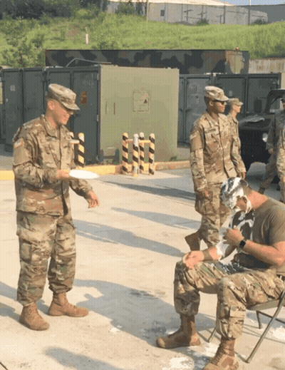 Soldiers Standing Around Man With Bandaged Head GIF