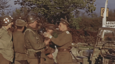 Soldiers Standing In Front Of Leiter Olzwar Sign GIF
