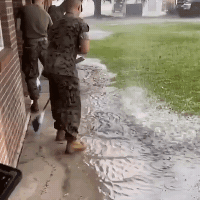 Soldiers Standing On Sidewalk In Flooded Area GIF