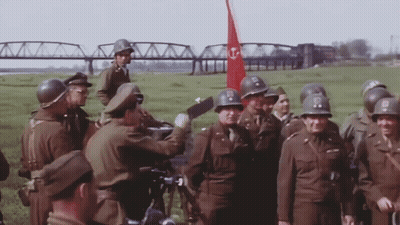Soldiers Standing With Red Flag With Letter T GIF