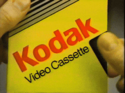 Someone Is Holding A Kodak Video Cassette GIF