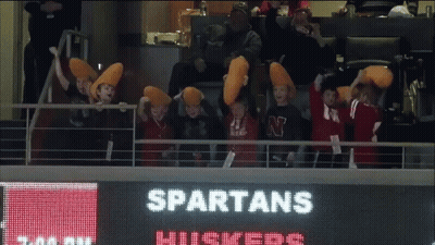Spartans Cheerleaders Sitting In Front Of Scoreboard GIF