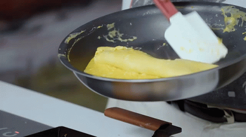 Spatula Stirring Eggs In Pan With Letter C On Stove GIF