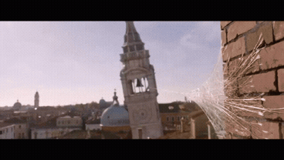 Spider Web Hanging From Brick Wall In Front Of Clock Tower GIF