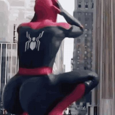 Spiderman Squatting In Front Of City Building GIF