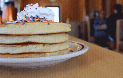 Stack Of Pancakes With Whipped Cream And Sprinkles GIF