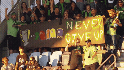 Stadium Crowd Holding Never Give Up Banner GIF