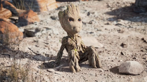 Statue Of Groot Sitting On Ground In Dirt GIF