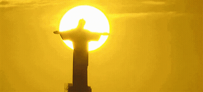 Statue Of Jesus In Front Of Yellow Sun GIF