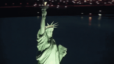 Statue Of Liberty Lit Up At Night Holding Book Saying Just Do It GIF