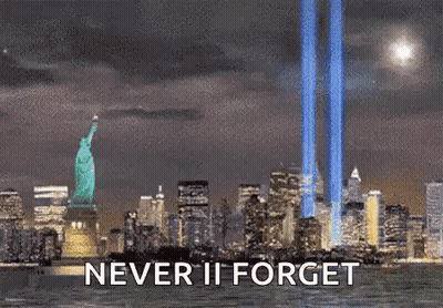 Statue Of Liberty Surrounded By City Skyline At Night Saying Never Ii Forget GIF