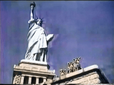 Statue Of Liberty Surrounded By Giraffes And Building GIF