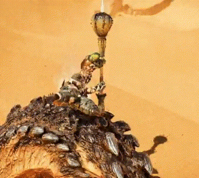 Statue Of Man Holding Torch On Rocks GIF