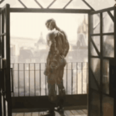 Statue Of Man On Balcony Looking Out Window GIF