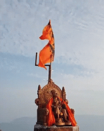 Statue Of Man Sitting On Throne With Orange Flag GIF