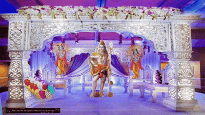 Statue Of Man With Trident In Front Of Purple Decoration GIF