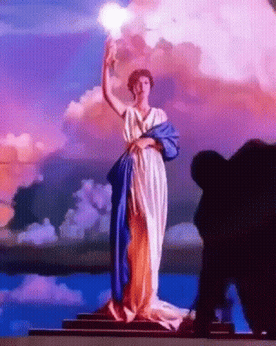 Statue Of Woman In Blue And White Dress Holding Light GIF