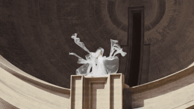 Statue Of Woman In White Dress In Front Of Building With Letter I GIF