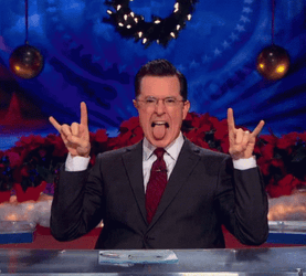 Stephen Colbert Making Hook Em Sign With Tongue Out GIF