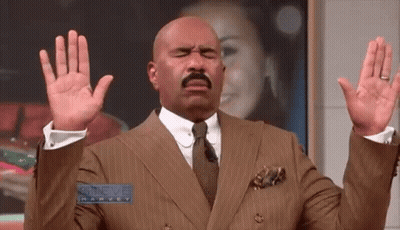 Steve Harvey In Suit And Tie With Hands Up GIF