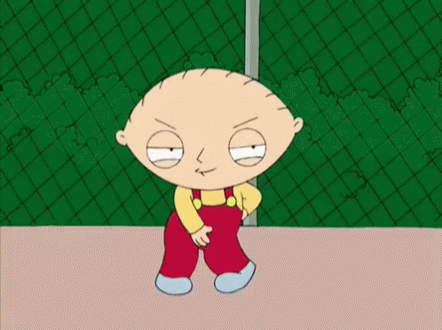 Stewie From The Family Guy Is Standing In Front Of A Chain Link Fence . GIF