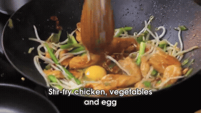 Stir Fry Chicken Vegetables And Egg In A Wok With A Wooden Spoon GIF