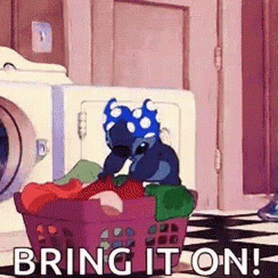 Stitch From Disney 'S Lilo And Stitch Is Sitting In A Laundry Basket Full Of Clothes . GIF
