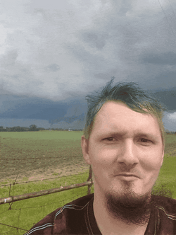 Storm Chaser Taking Video With Dark Clouds GIF
